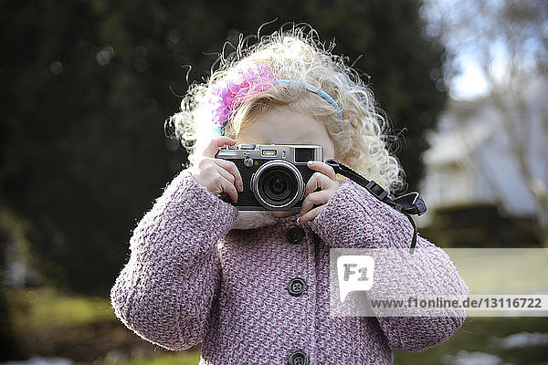 Girl photographing while standing in park