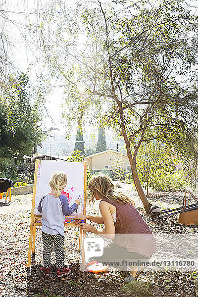 Mutter und Tochter malen im Hinterhof