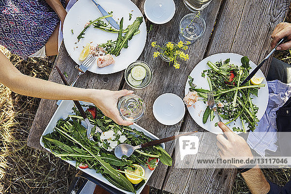 Ausgeschnittenes Bild eines Mannes und einer Frau  die bei Tisch Rucola-Salat essen