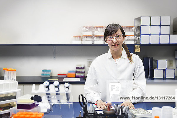 Portrait of confident female scientist standing in laboratory