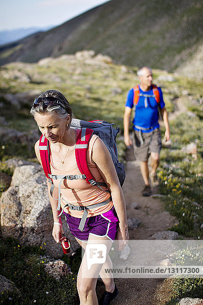 Hikers with backpacks walking on mountain