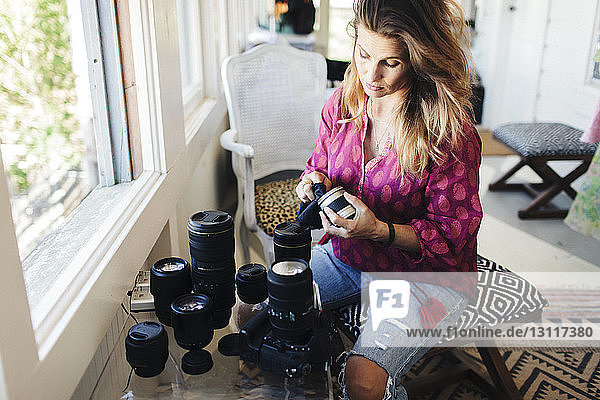 High angle view of woman cleaning camera lens