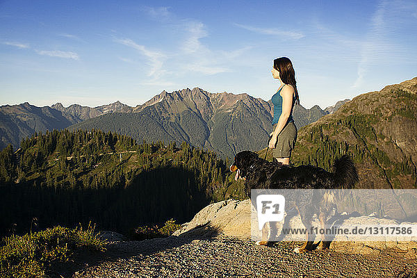 Seitenansicht einer Frau mit Hund auf einem Berg