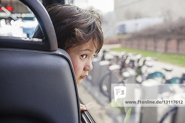 Junge schaut durch Fenster  während er im Bus reist
