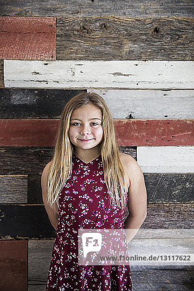 Porträt eines lächelnden Mädchens an Holzwand