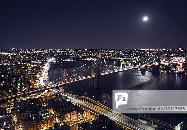 Hochwinkelansicht der beleuchteten Stadtlandschaft und der Brooklyn Bridge bei Nacht