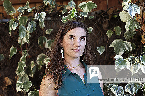 Portrait of woman standing against plants