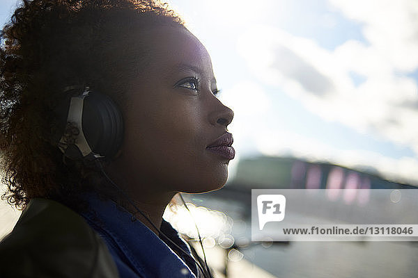 Close-up of thoughtful woman listening music