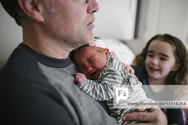 Vater tröstet weinendes Baby Mädchen für Tochter zu Hause