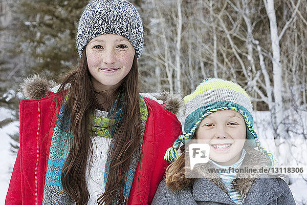 Portrait of happy sisters in warm clothing