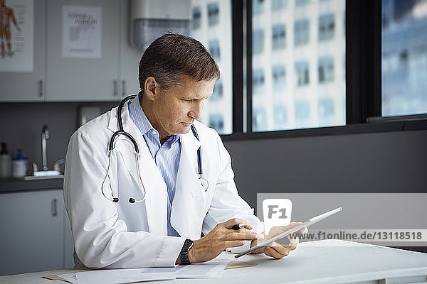 Männlicher Arzt mit Tablet-Computer in der Klinik