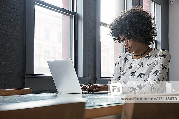 Geschäftsfrau benutzt Laptop-Computer  während sie im Büro am Schreibtisch sitzt