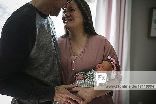 Glückliche Eltern mit neugeborener Tochter zu Hause
