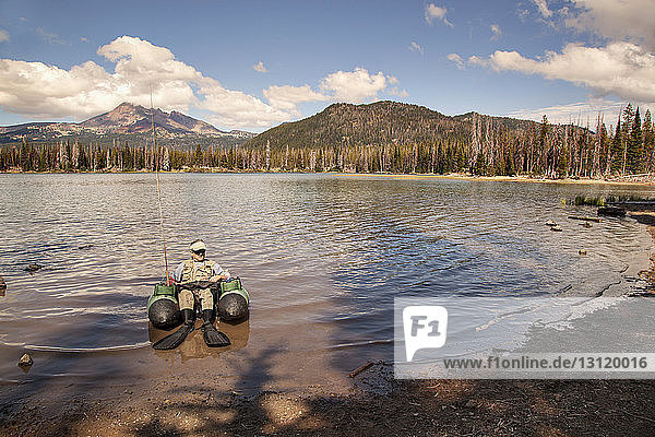 Man relaxing on tender raft in lake