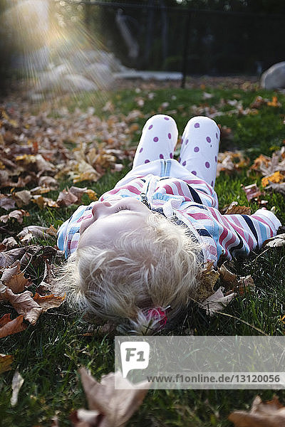 Girl relaxing on grassy field in park during autumn