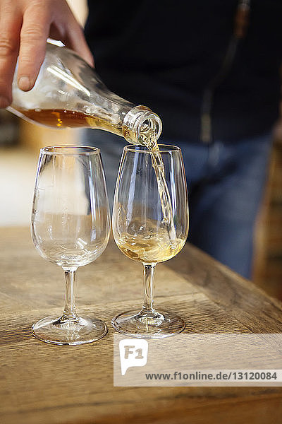 Cropped image of man pouring wine in wineglasses