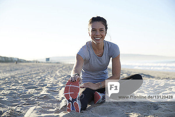 Porträt einer fröhlichen Frau beim Sport am Strand