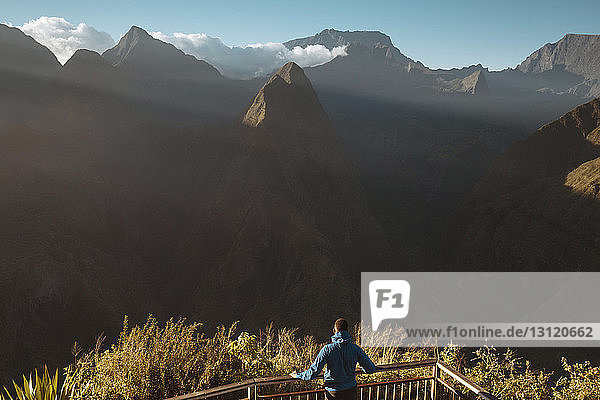 Rückansicht eines Mannes  der Berge betrachtet  während er auf einem Beobachtungspunkt steht