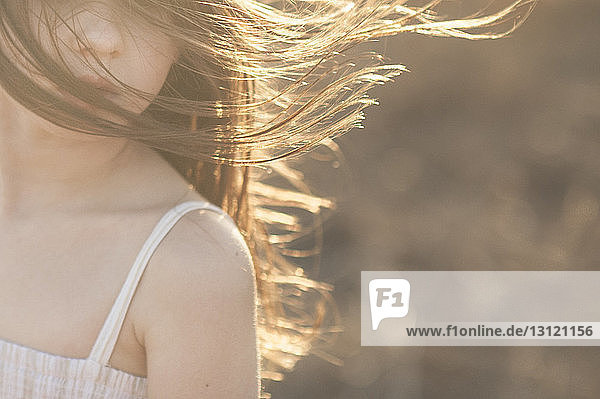 Ausgeschnittenes Bild eines Mädchens mit zerzaustem Haar während eines sonnigen Tages
