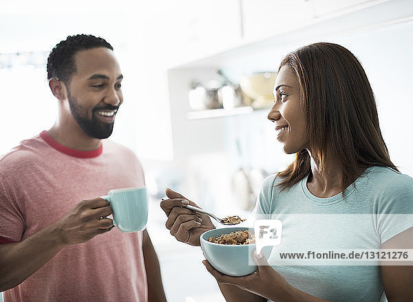 Ehepaar frühstückt  während es zu Hause in der Küche steht