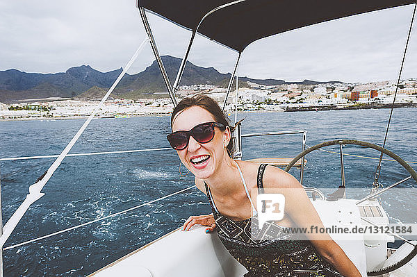 Smiling woman sitting in boat sailing on sea