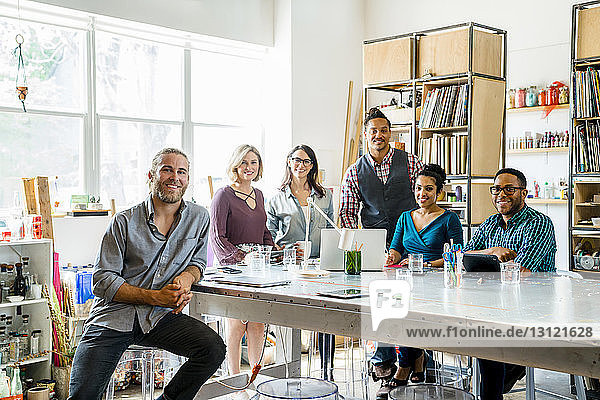 Portrait of happy business people at conference table in office