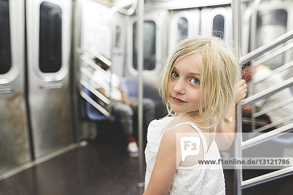 Portrait of smiling girl standing in train