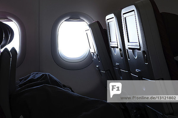 Flugzeugfenster und Passagiersitze während des Fluges