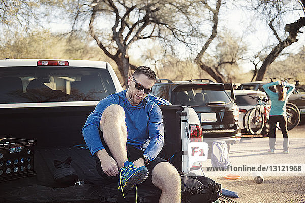 Man wearing sports shoe while sitting in pick-up truck