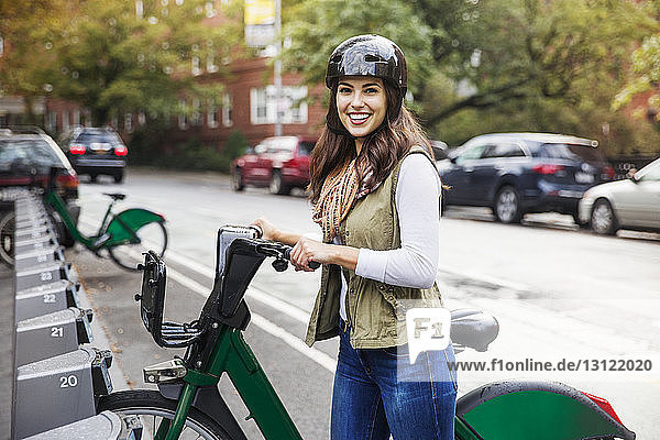 Porträt einer lächelnden Frau mit Fahrrad auf einem Parkplatz