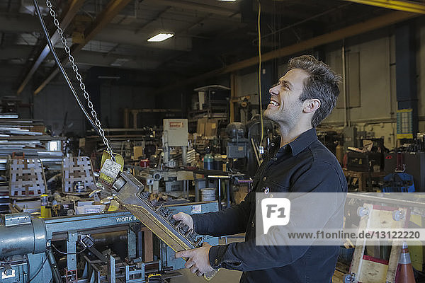 Lächelnder Ingenieur bei der Bedienung von Geräten in der Fabrik