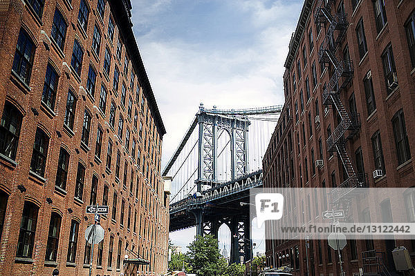 Niedrigwinkelansicht der Brooklyn-Brücke und der Gebäude in der Stadt gegen den Himmel