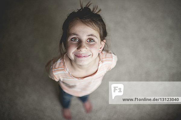 Hochwinkelporträt eines zu Hause stehenden lächelnden Mädchens