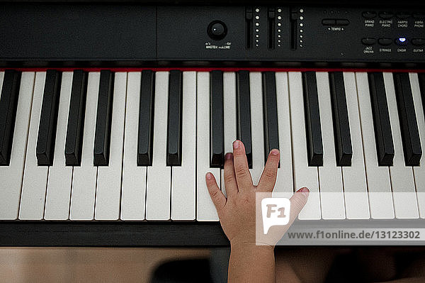 Abgehackte Hand eines Jungen  der zu Hause Klavier spielt