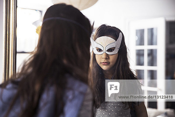 Girl wearing eye mask looking in mirror at home