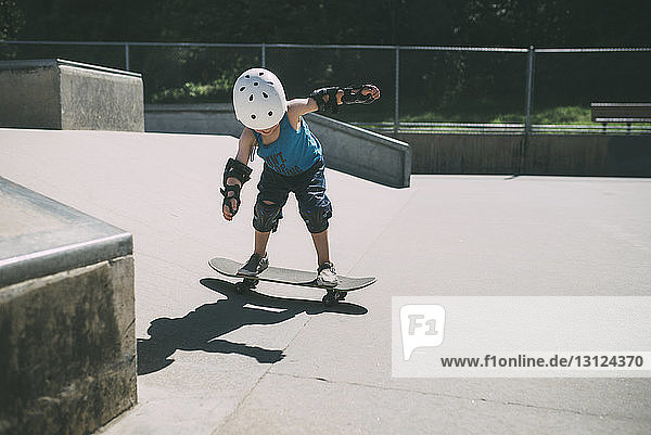 Skateboarden von Jungen in voller Länge im Sommer im Skateboard-Park