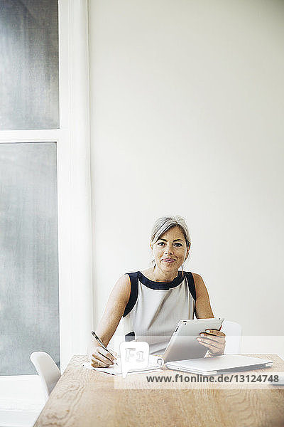 Porträt einer selbstbewussten Geschäftsfrau  die am Konferenztisch arbeitet