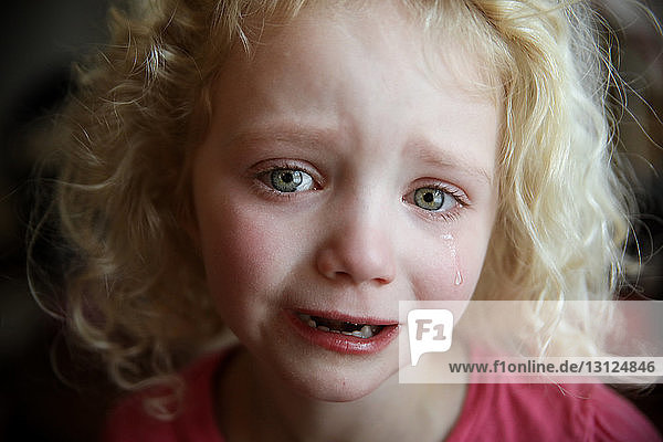 Close-up portrait of girl crying at home
