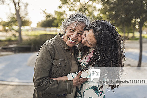 Glückliche Tochter umarmt ältere Mutter im Park