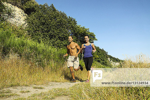 Paar joggt auf dem Feld gegen klaren Himmel