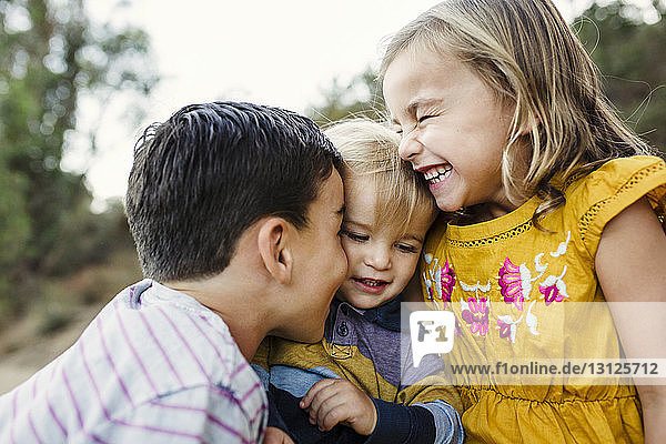 Close-up of cheerful siblings at field