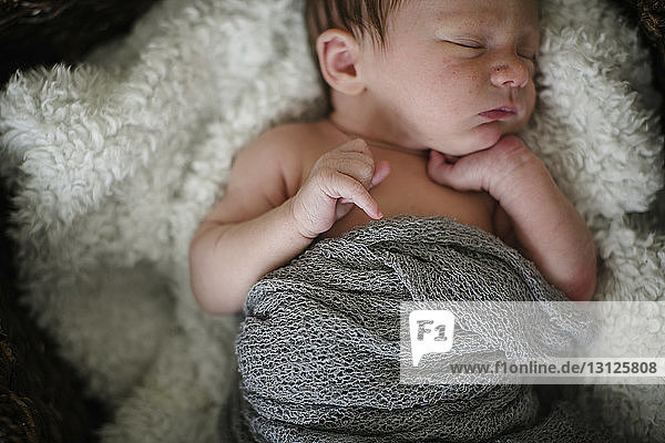 Hochwinkelaufnahme eines hemdlosen Neugeborenen  der zu Hause auf dem Bett schläft