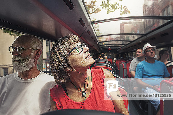 Mature couple travelling in bus on sunny day