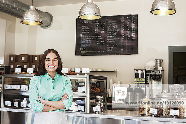 Porträt eines glücklichen Besitzers im Café stehend
