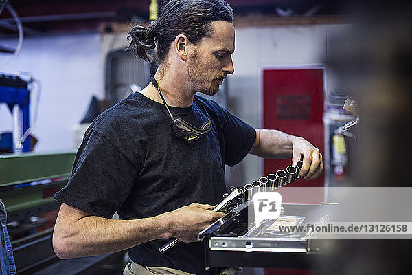 Mechanic holding hand tool at auto repair shop