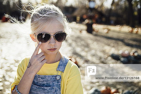 Close-up of girl wearing sunglasses while standing on field