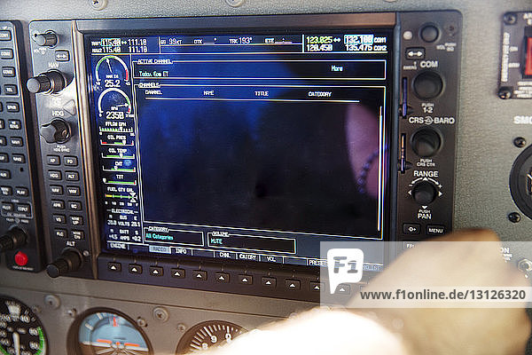 Beschnittenes Bild des Piloten bei der Benutzung des Bedienfeldes im Flugzeugcockpit