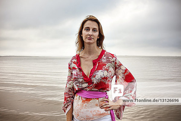 Porträt einer Frau  die am Meeresufer gegen den Himmel steht