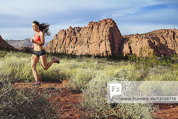 Athlet joggt auf Feld gegen Berge
