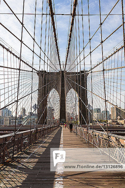 Brooklyn Bridge against sky in New York city during sunny day